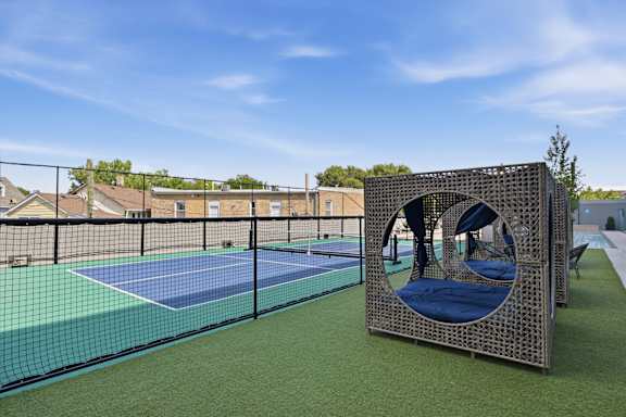 A playground with a blue tennis court and a play structure.