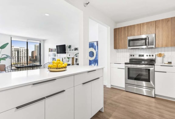 a white kitchen with stainless steel appliances and a counter top
