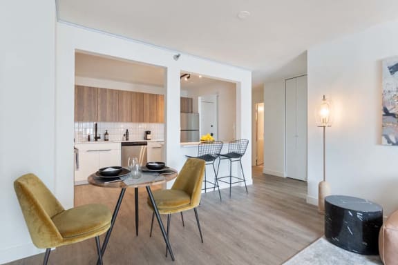 a living room and dining room with a table and chairs