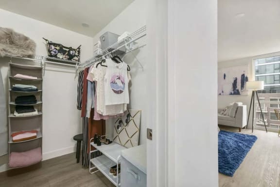 the closet in the master bedroom has a vanity and shelves with clothes