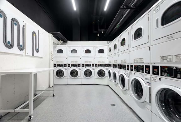 a row of washers and dryers in a laundry room