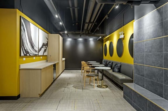 a dining room with tables and chairs and a yellow wall