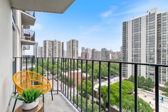 a balcony with a view of a city and a chair