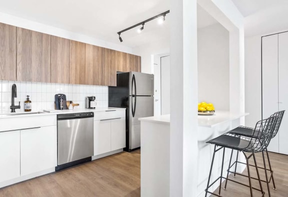 a kitchen with a white counter and a stainless steel refrigerator