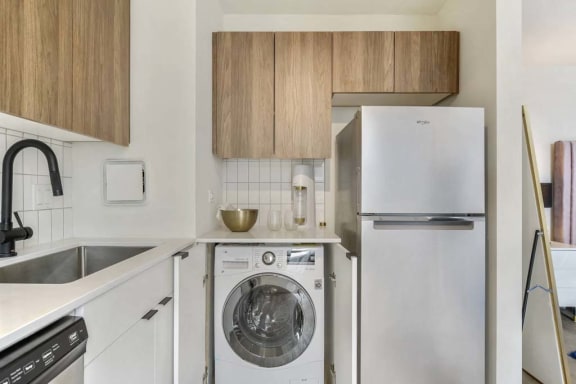 a white kitchen with a washing machine and a refrigerator