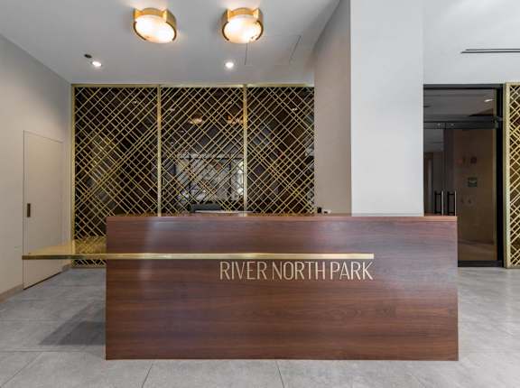 A wooden reception desk with the words "River North Park" on it.