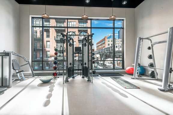 A gym with a view of the city outside the window.