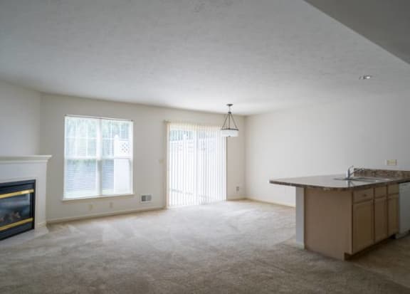 Great room with view of living, dining and kitchen areas, fireplace and sliding doors to private patio