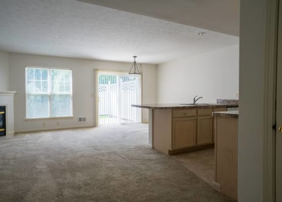 Great room with view of living, dining and kitchen areas, fireplace and sliding doors to private patio