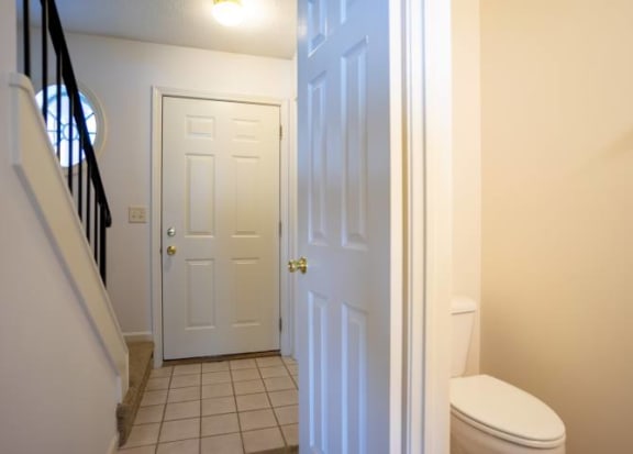 First floor powder room and view of foyer and stairway to second floor