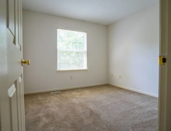 View of typical carpeted bedroom with window