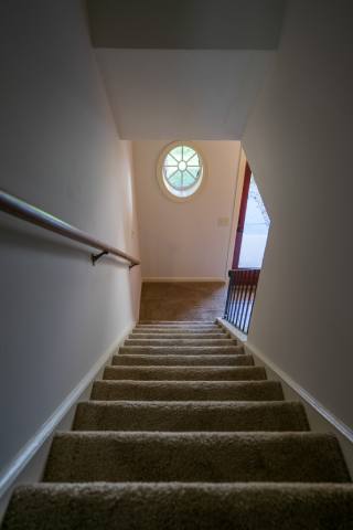 View from second floor down staircase to front door