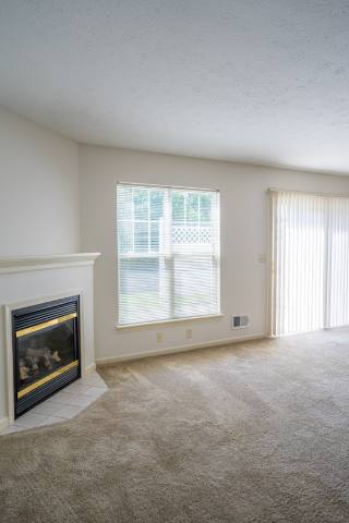Another view of great room showing fireplace and sliding glass doors to private patio