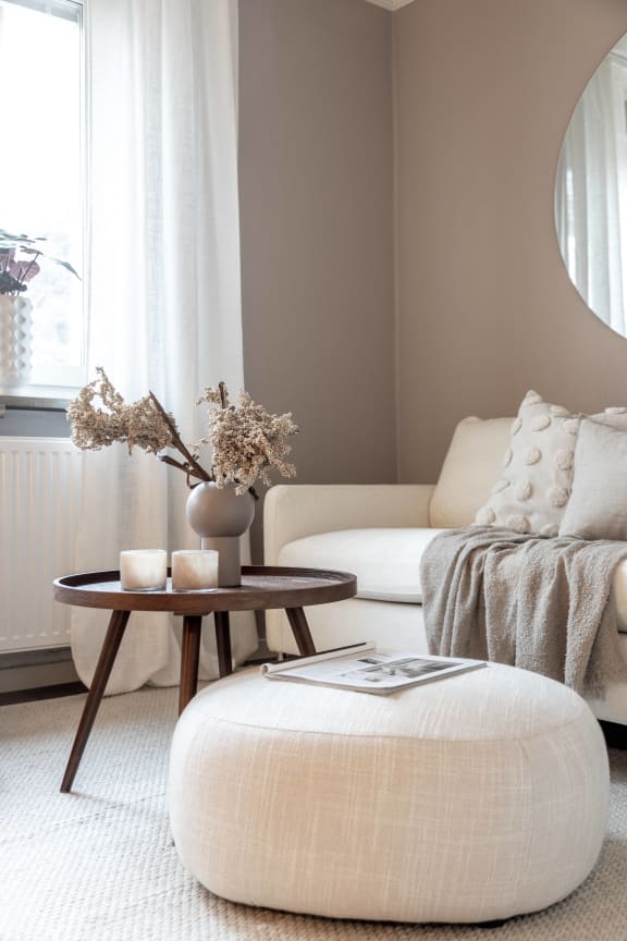 a living room with a white couch and a table with a vase on it at Capital Flats &amp; Magnolia Square Apartments, Raleigh, NC, 27601