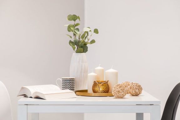 a white desk with a vase and candles on it at Capital Flats &amp; Magnolia Square Apartments, Raleigh, NC, 27601