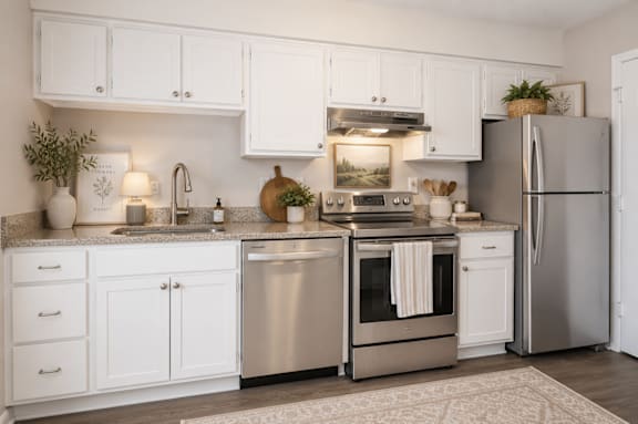 A modern kitchen with white cabinets and stainless steel appliances.