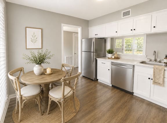 A kitchen with a table and chairs in the middle of the room.
