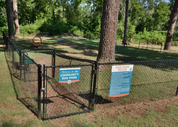 a dog park with a chain link fence and a sign that says community dog park at Parkside at Five Points, Raleigh