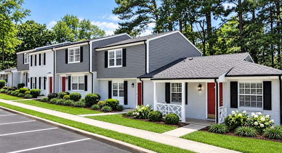 A row of houses with red doors and white trim.