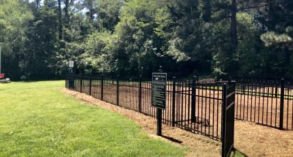 a park with a fence and a sign in the grass at Midtown Park Townhomes, Raleigh, 27609