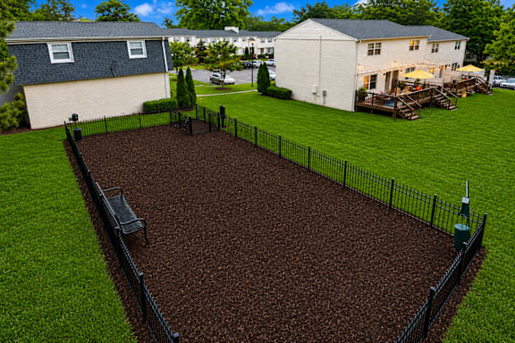 A black fence surrounds a brown dirt area.