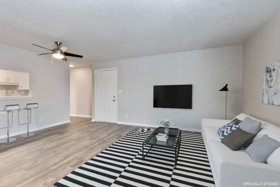 an open living room with a white couch and a black and white rug