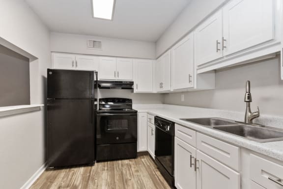a kitchen with black appliances and white cabinets