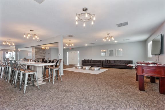 a game room with a pool table and a bar with chairs
