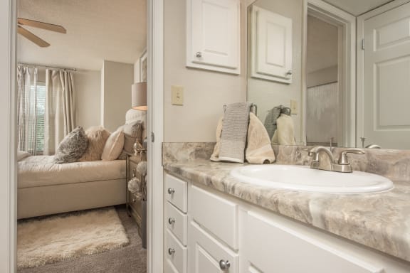 a bathroom with a sink and a mirror and a couch