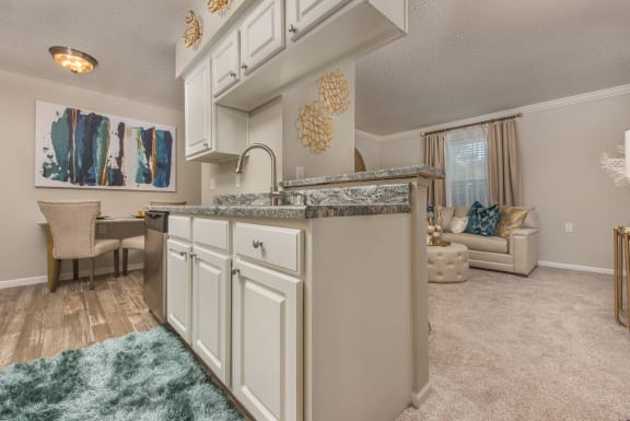 a kitchen with white cabinets and a living room with a couch