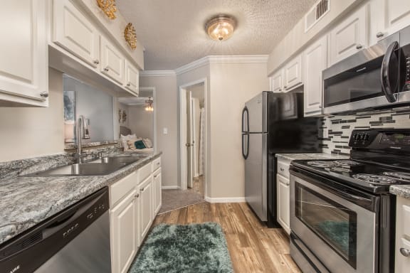 a kitchen with stainless steel appliances and marble counter tops