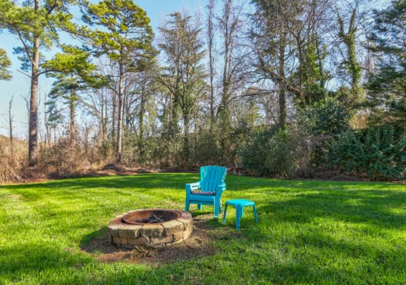 a backyard with a fire pit and two chairs in the grass at Parkside at Five Points, Raleigh