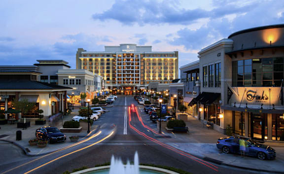 A city street with cars and a fountain in the foreground.