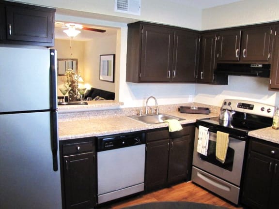 a kitchen with stainless steel appliances and black cabinets at Midtown Park Townhomes, Raleigh, 27609