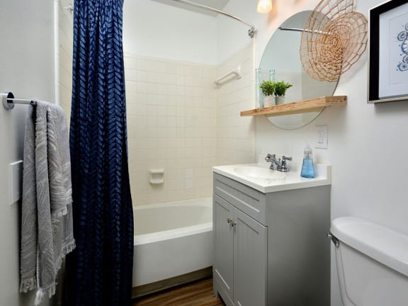 a small bathroom with a sink and a tub and a shower curtain at Capital Flats &amp; Magnolia Square Apartments, Raleigh, NC, 27601