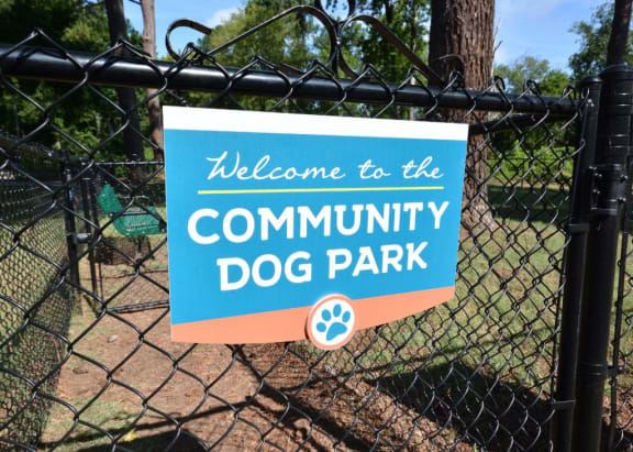 a welcome to the community dog park sign on a fence at Parkside at Five Points, Raleigh