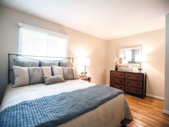 a bedroom with a bed and a dresser and a window at Parkside at Five Points, Raleigh