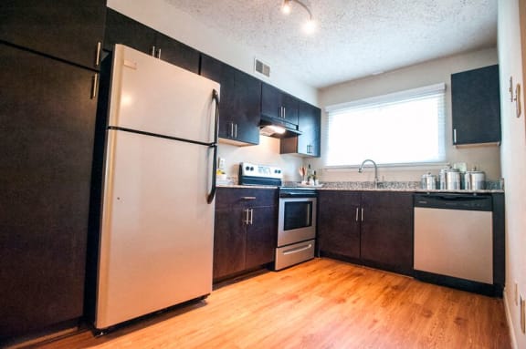 a kitchen with stainless steel appliances and a wood floor at Parkside at Five Points, Raleigh