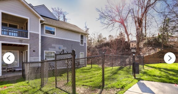 the back yard of a house with a fenced yard and a chain link fence