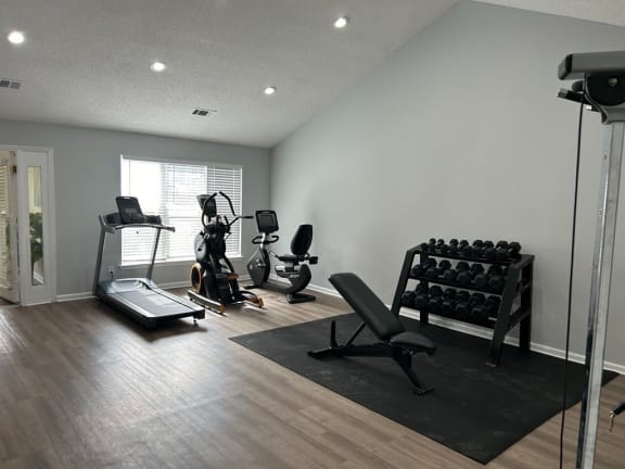 a home gym with exercise equipment and a window