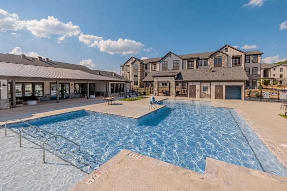 A large swimming pool in front of a residential building.