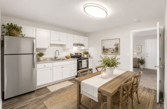 A kitchen with a table and chairs in the middle of the room.