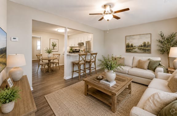A living room with a white couch, a wooden coffee table, and a ceiling fan.