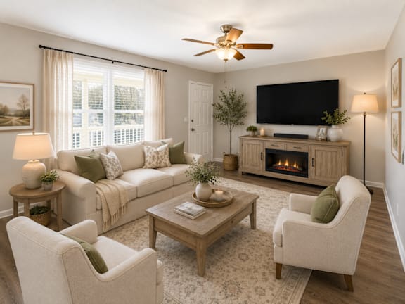 A living room with a couch, chairs, a coffee table, and a fireplace.