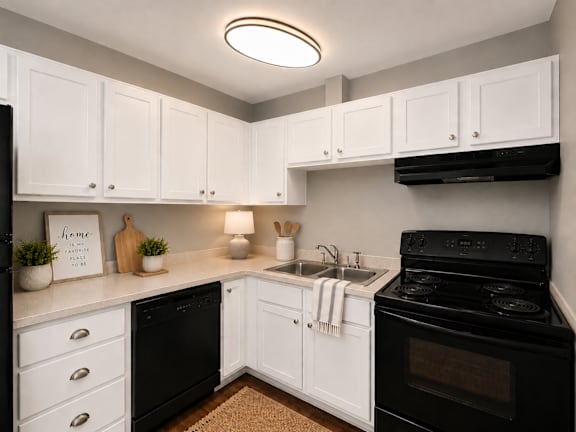 A kitchen with black appliances and white cabinets.