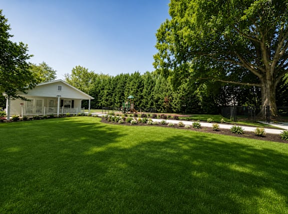 A white house with a green lawn in front.