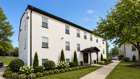 A white building with a black roof and a black door.