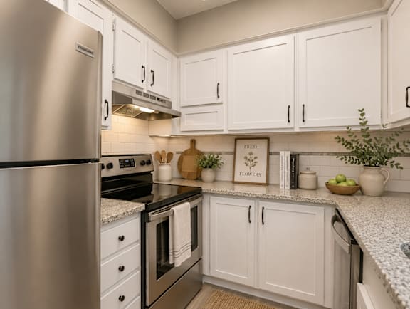 A kitchen with white cabinets and a stainless steel refrigerator.