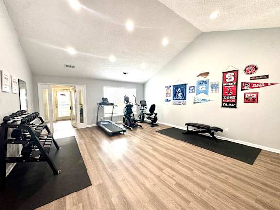 A gym with a variety of equipment including treadmills, weights, and exercise machines.