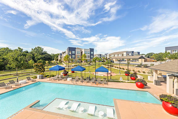 A pool with a slide and a building in the background.